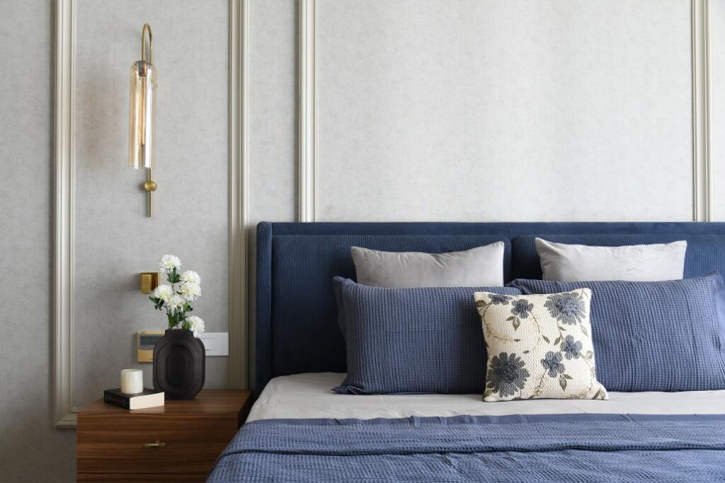 Deep Blue Bedroom with Gray Textured wal, Wooden Nightstand and Elegant Lighting Fixtures; The Flair House